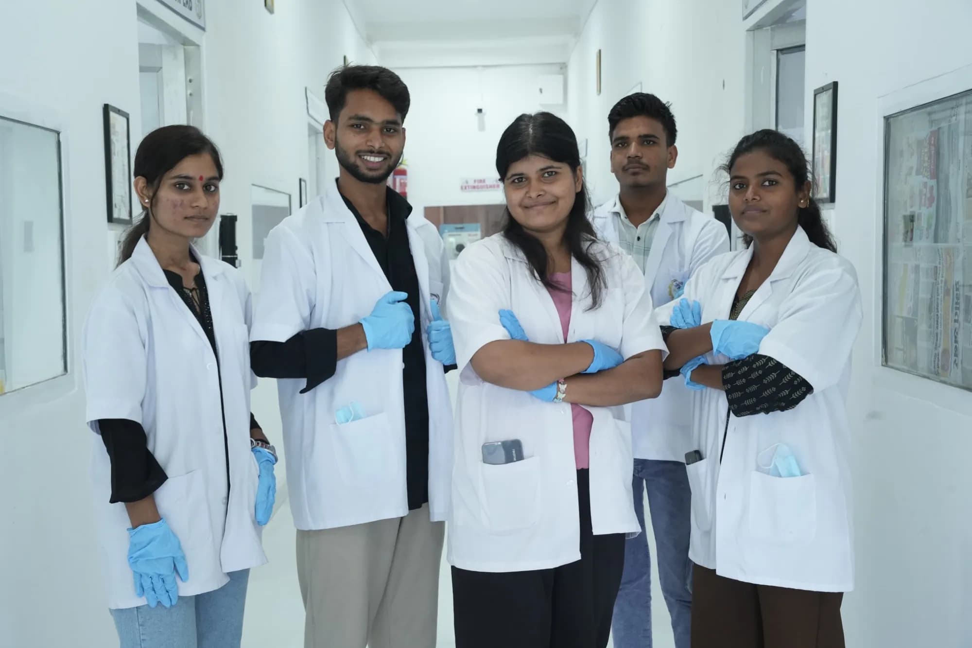 Group of biotechnology students smiling together in lab coats and gloves